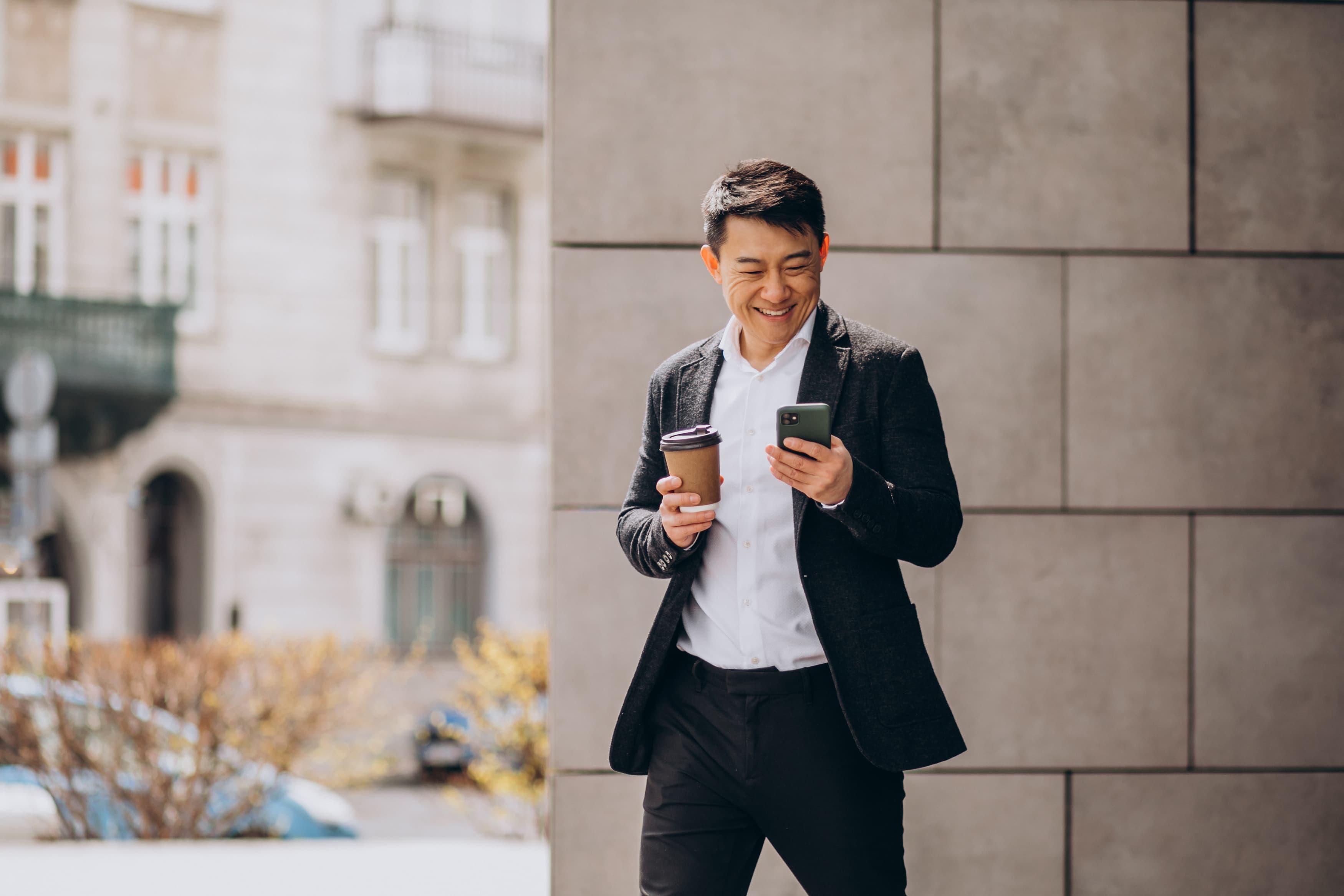 Man holding a coffee and phone
